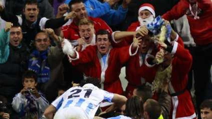 Los jugadores blanquiazules celebran uno de los tres goles de ayer del Málaga contra el Real Madrid.