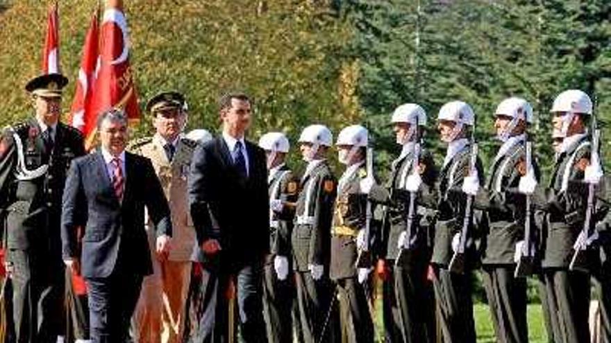 El presidente turco, Abdullah Gul (2-i) y su homólogo sirio, Bashar al-Assad (d), caminan junto a la guardia de honor turca durante la ceremonia de bienvenida en el palacio de Cankaya en Ankara, Turquía, ofrecida al mandatario sirio hoy, miércoles 17 de octubre. Bashar al-Assad y su esposa están en Turquía para una visita oficial de tres días.