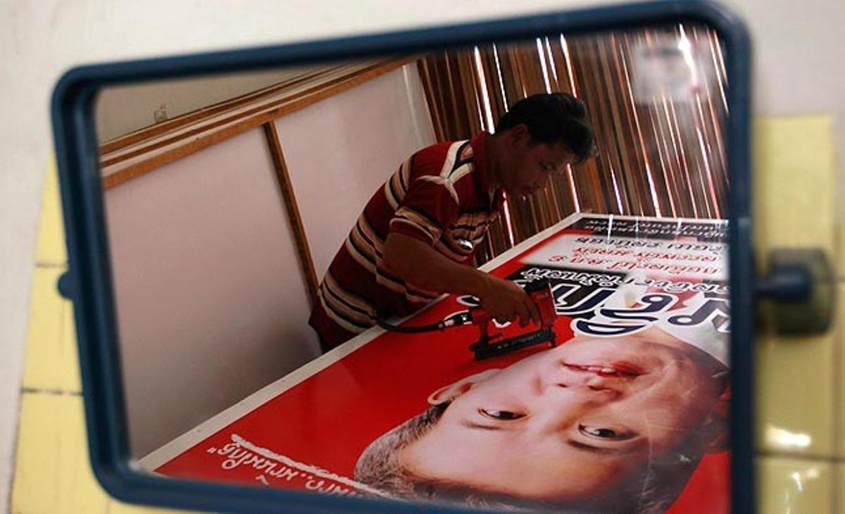 Un treballador del partit tailandès Puea Thai Party emmarca aquest dimarts a Bangkok un cartell electoral per a la campanya prèvia a les eleccions generals al Parlament del pròxim 3 de juliol