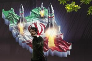 Un hombre pasa junto a un mural bélico en Teherán, este viernes.
