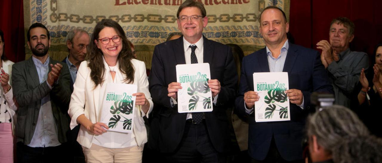 Mónica Oltra, Ximo Puig y Rubén Martínez Dalmau muestran la reedición del pacto del Botànic, tras firmarlo ayer en el salón de Felipe II del Castillo de Santa Bárbara de Alicante. Al fondo, miembros del comité negociador.