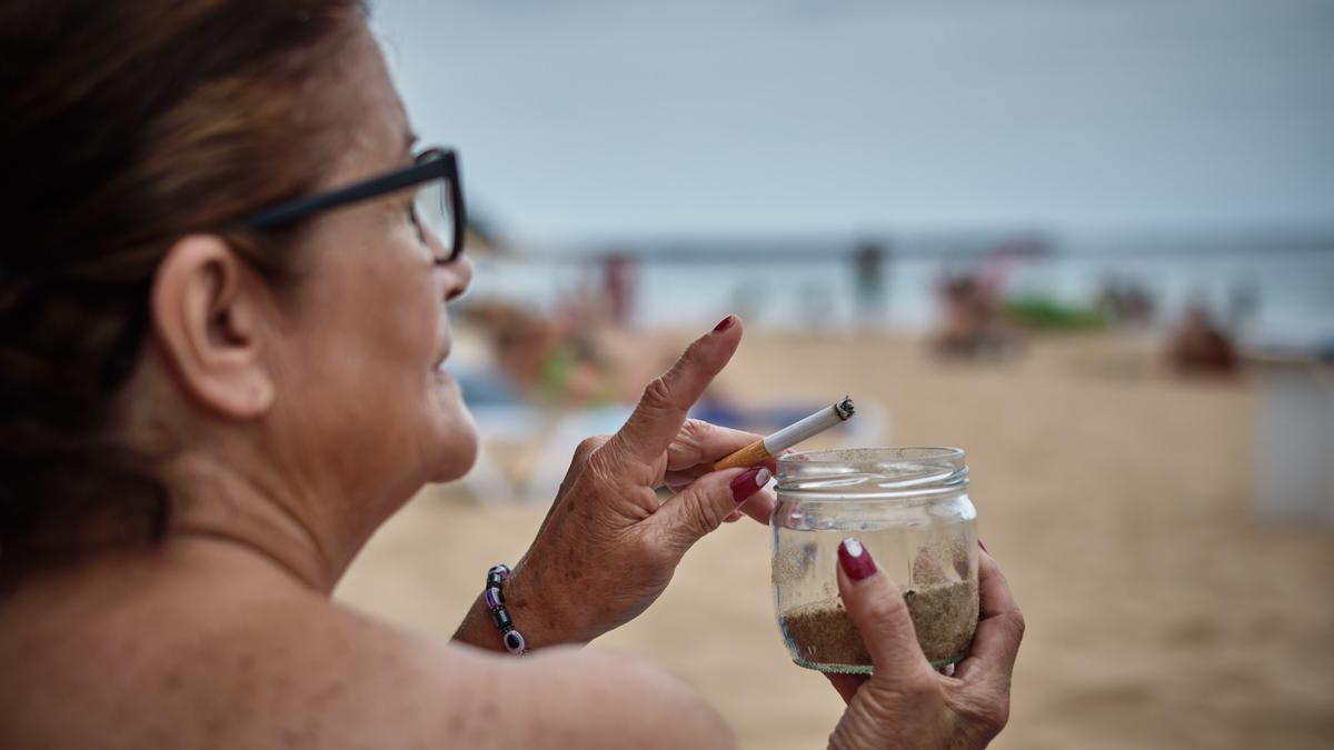 Una ciuadana fuma en la playa de Las Teresitas.