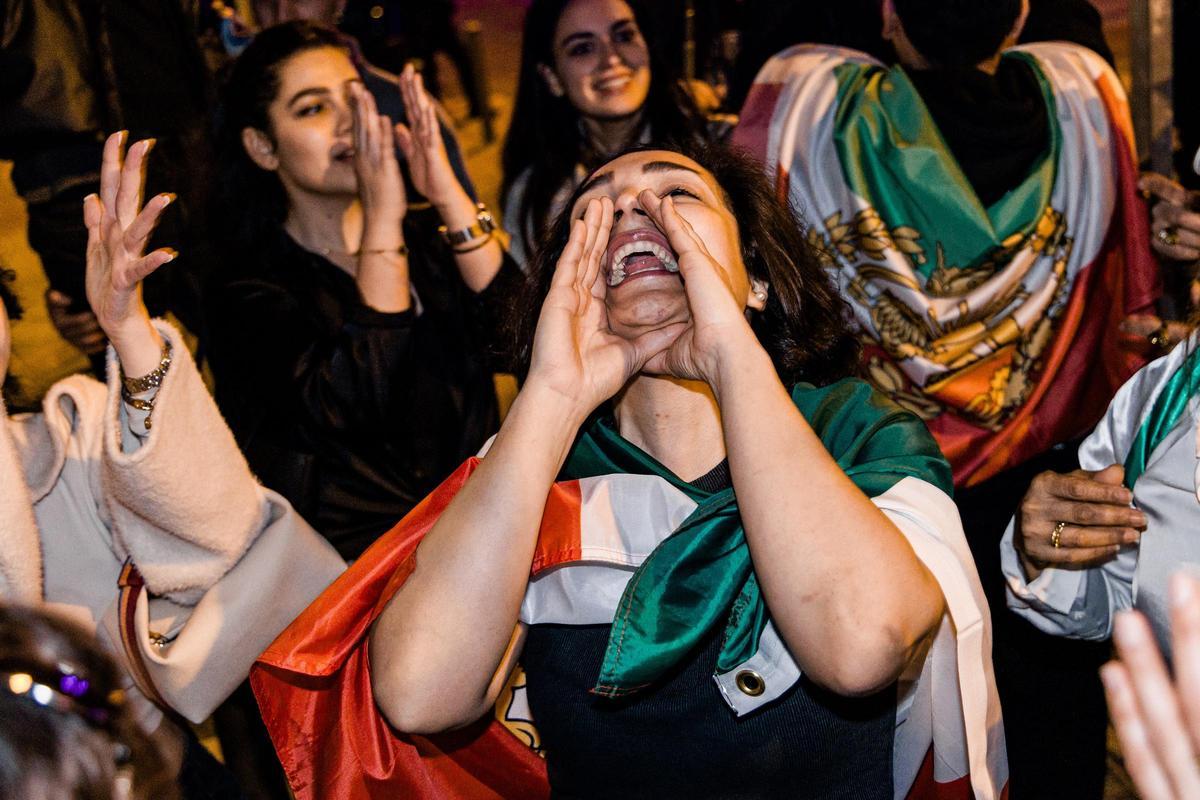 Decenas de personas durante una concentración de exiliados iraníes a favor de la intervención militar de EEUU e Israel, ante la embajada de Irán, el 28 de febrero de 2026, en Madrid