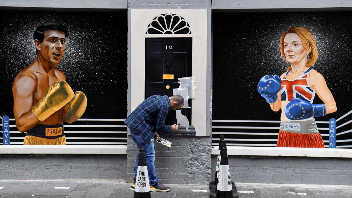 El artista Ciaran Gallagher finaliza su mural de los candidatos a liderar el Partido Conservador, Rishi Sunak y Liz Truss, este miércoles en Belfast.