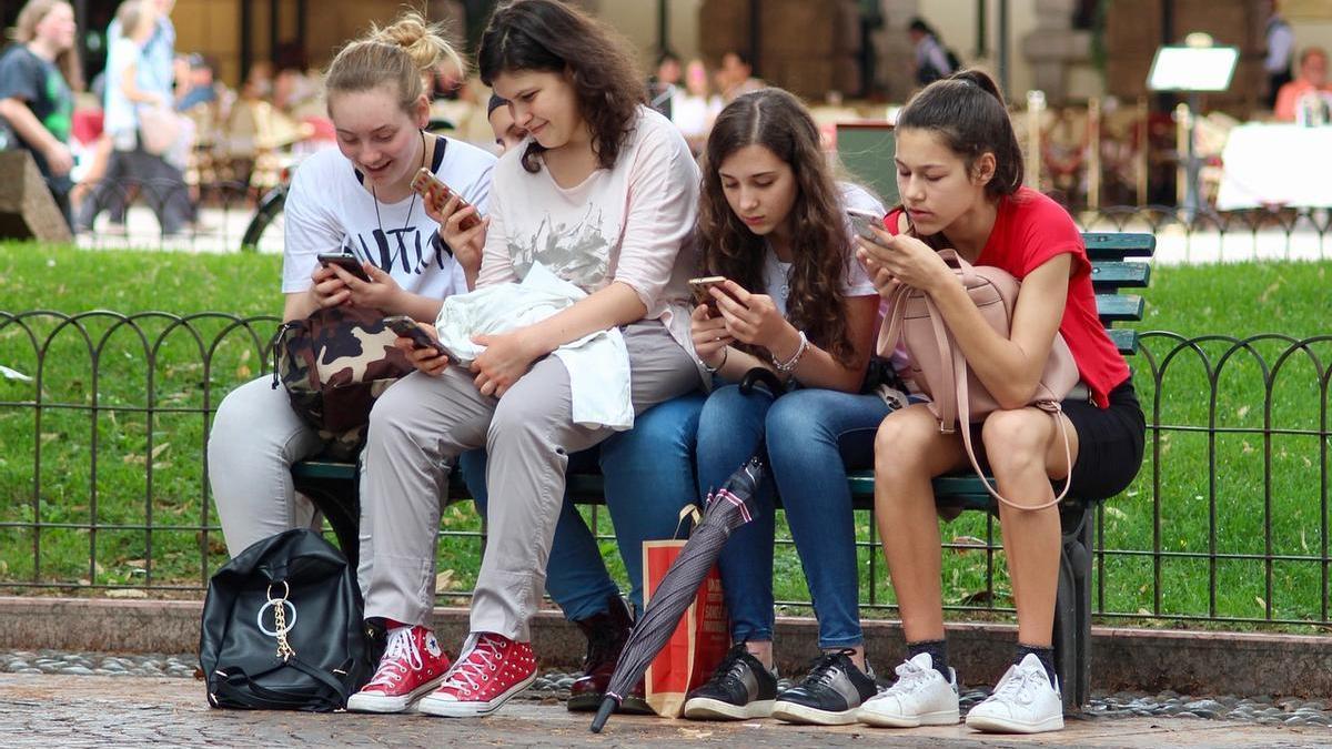 Adolescentes con sus móviles.