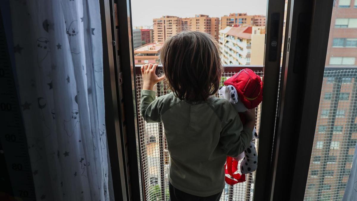 Un niño observa la calle durante el confinamiento en abril de 2020.   | F. CALABUIG