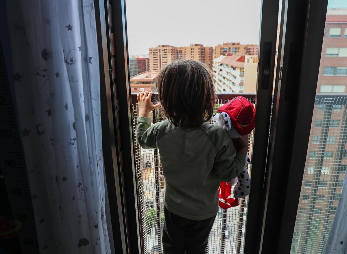 Un niño observa la calle durante el confinamiento en abril de 2020.   | F. CALABUIG