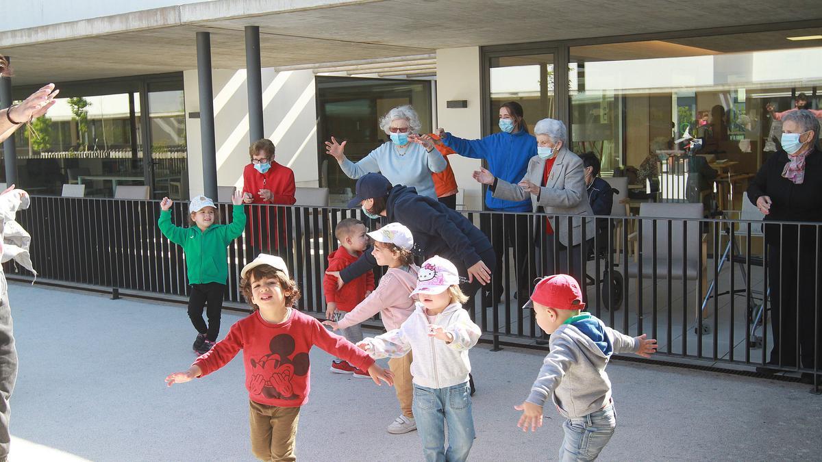 Mayores y niños vuelven a interactuar en el centro intergeneracional, con distancias y en el exterior. // IÑAKI OSORIO