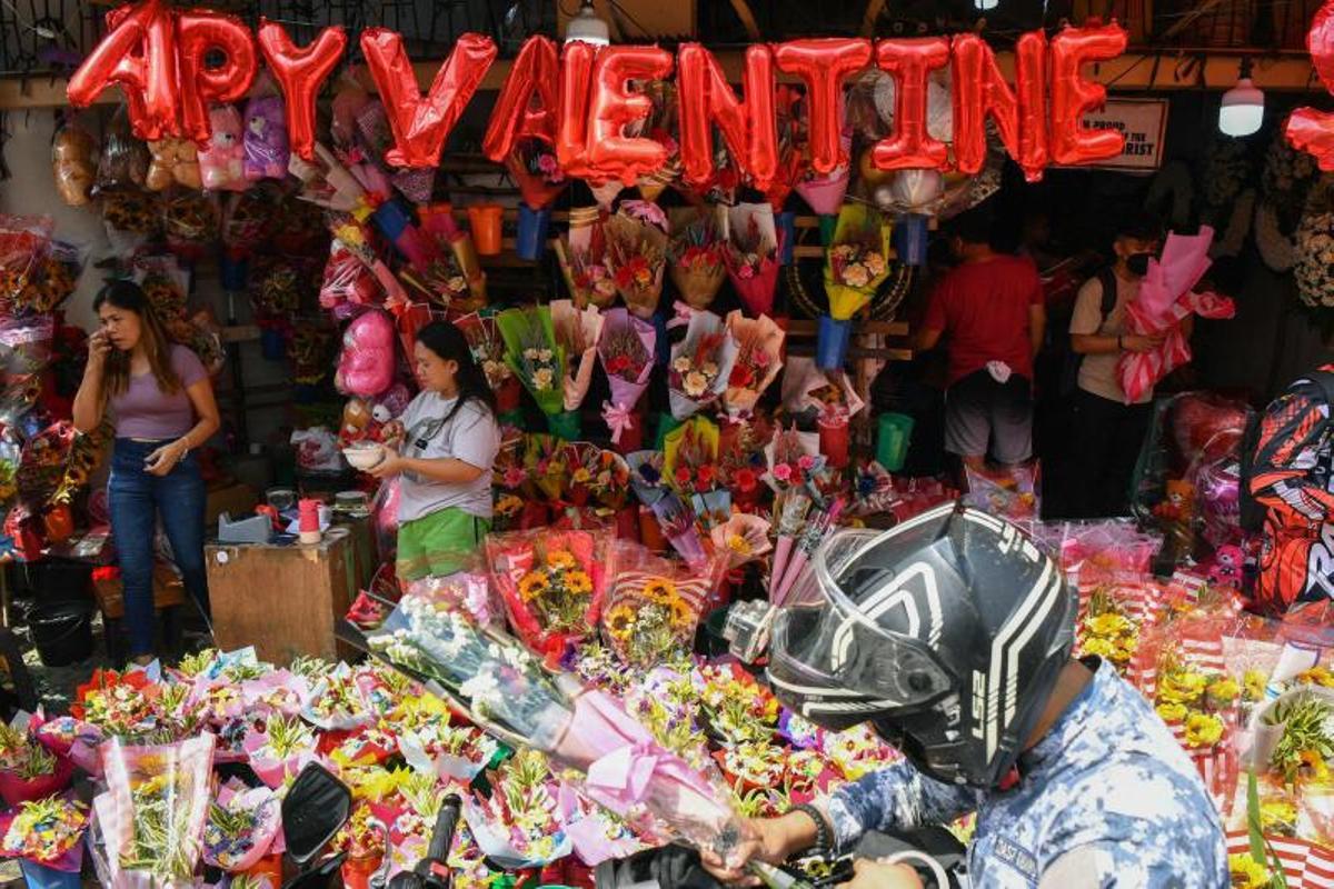 La gente compra ramos de flores el Día de San Valentín en un mercado de flores en Manila