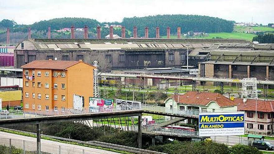 La nave de hornos de fosa, con sus características chimeneas, y parte del taller de laminación, a la derecha.