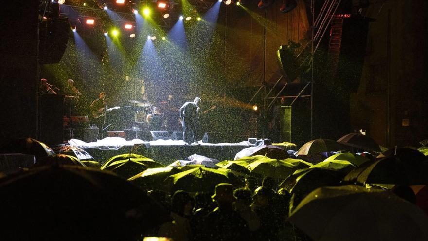 Los más fieles a Jaume Anglada resistieron bajo el paraguas y el cantautor hizo un concierto en formato reducido. | GUILLEM BOSCH
