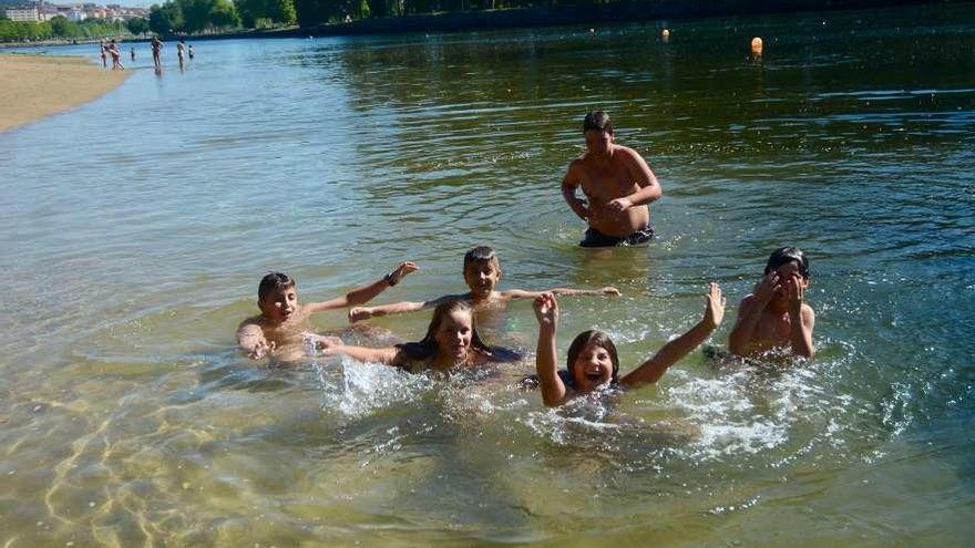 Niños y mayores disfrutan de las aguas del Lérez en la playa fluvial. // Rafa Vázquez