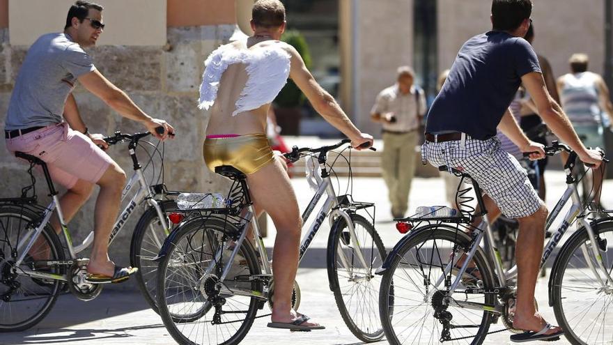 Tres ciclistas circulan por Valencia.