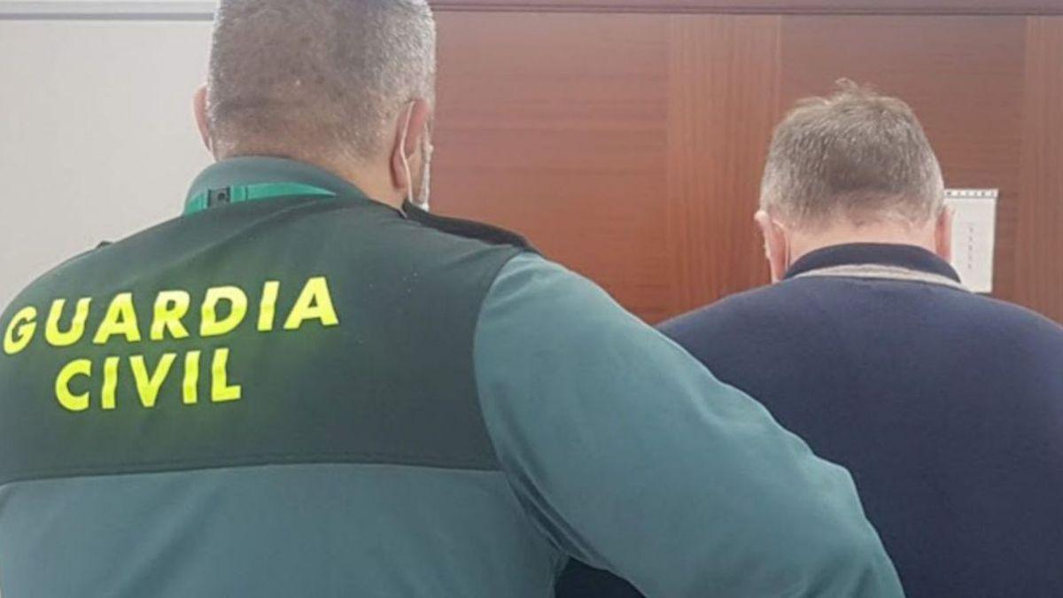 Un guardia civil, junto al presunto estafador arrestado.