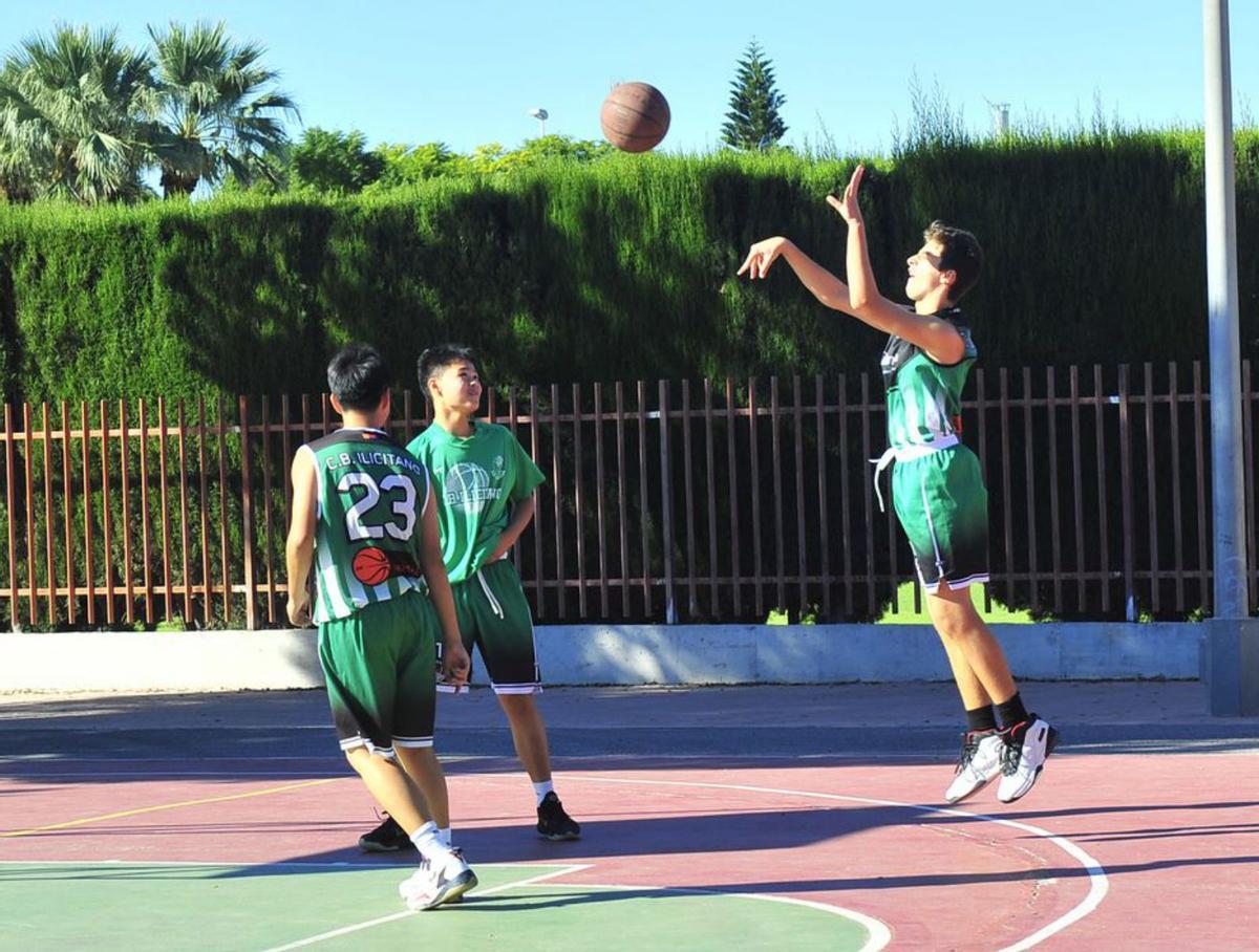 Un grupo de jóvenes juegan al baloncesto en una pista municipal y, a la derecha, una partida de hockey en el centro. | MATÍAS SEGARRA
