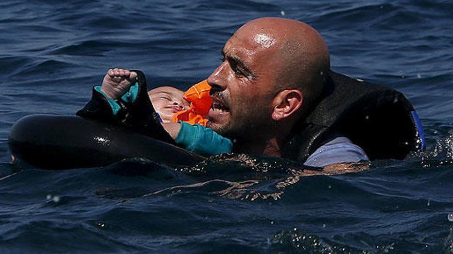 Un hombre trata de llegar a la orilla con un bebé.