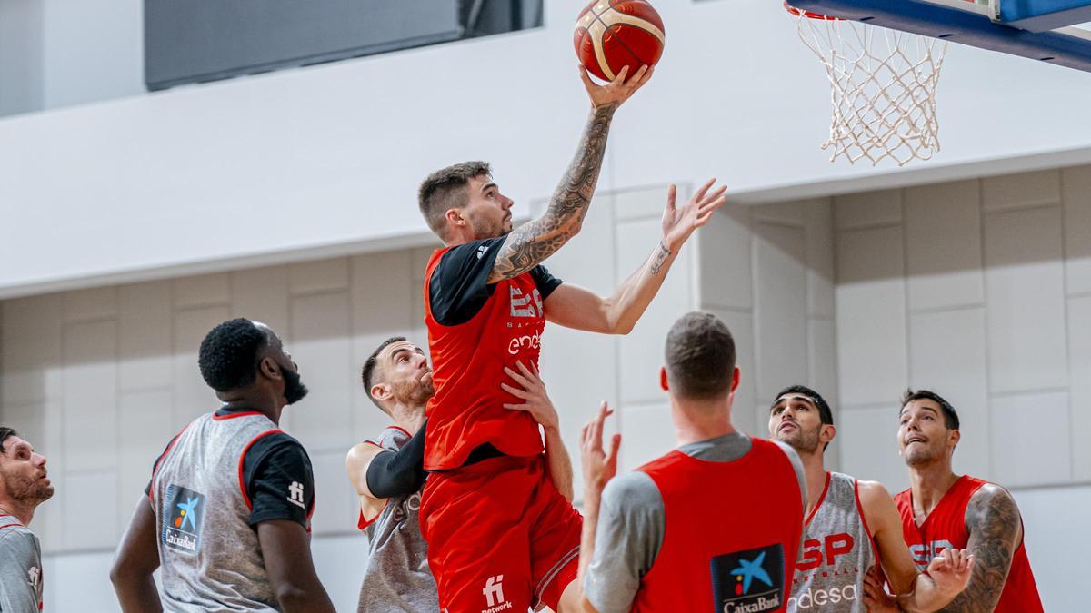 Juancho se eleva hacia la canasta ante la defensa de Víctor Claver en el último entrenamiento previo al debut