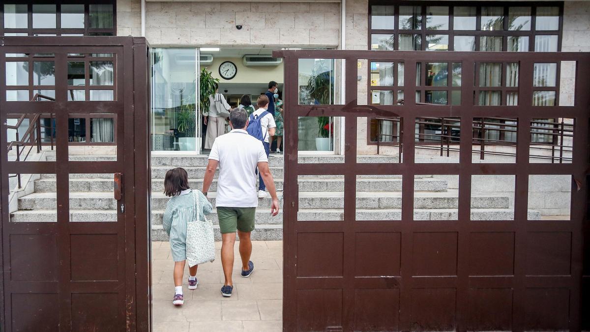 Un padre y su hija entrando en un colegio.