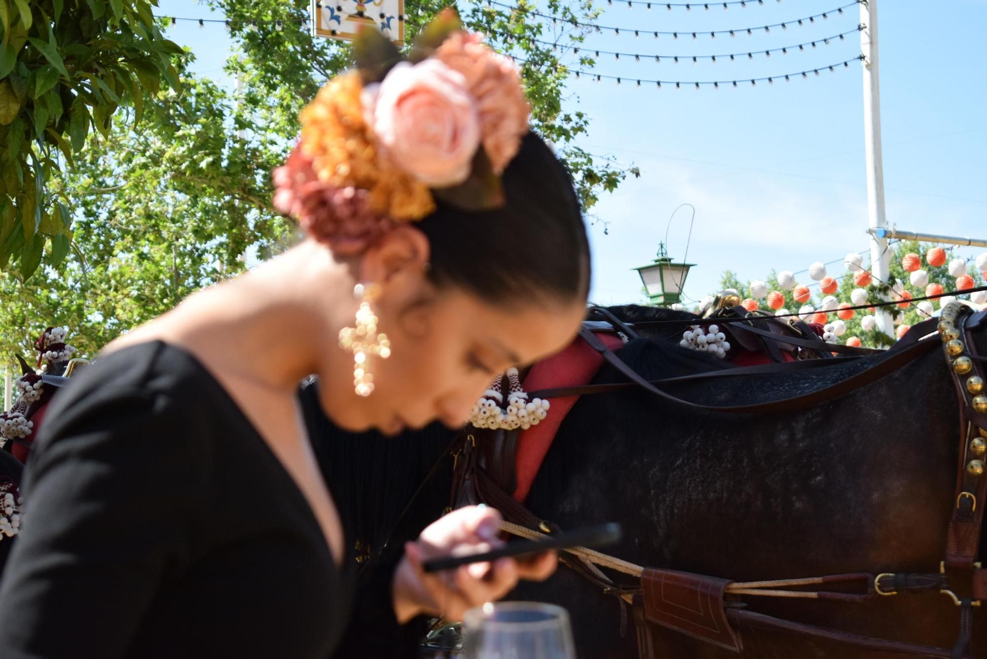Joven flamenca utiliza su teléfono móvil en el Real