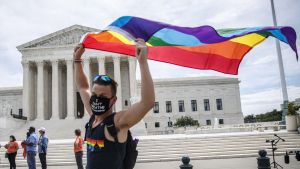 Un simpatizante LGBTQ camina con una bandera frente al Tribunal Supremo en Washington, DC.