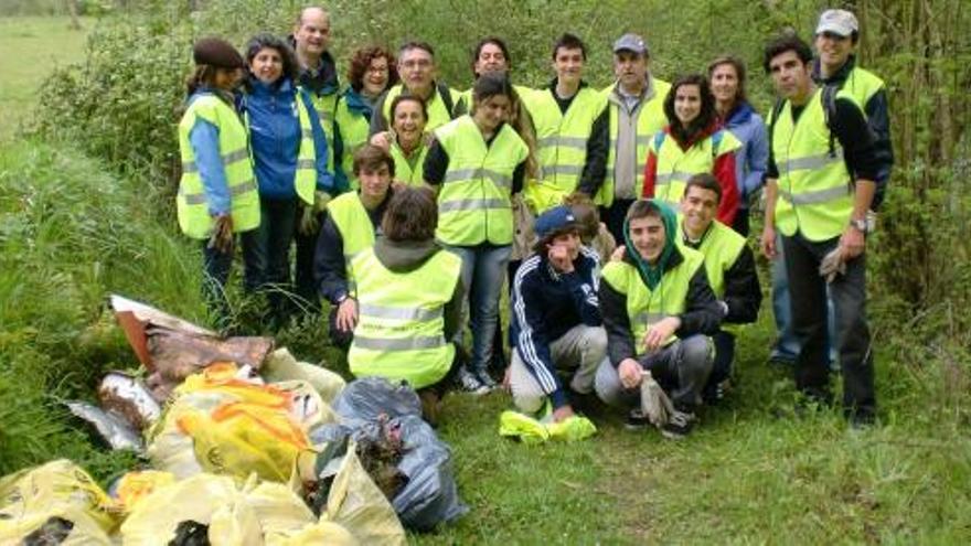 El grupo de voluntarios, con las bolsas de la basura recogida. A la derecha, Alberto Domínguez, profesor del San Ignacio, durante la limpieza.