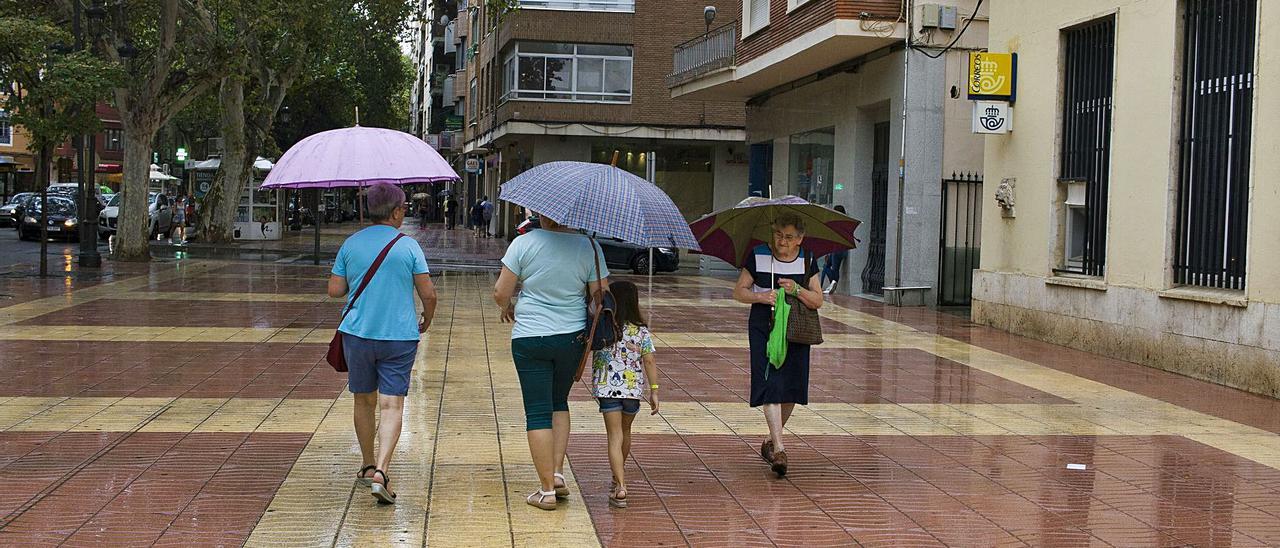 Vecinas de Xàtiva pasean por la Albereda Jaume I en una mañana lluviosa, en una imagen de este verano. | PERALES IBORRA