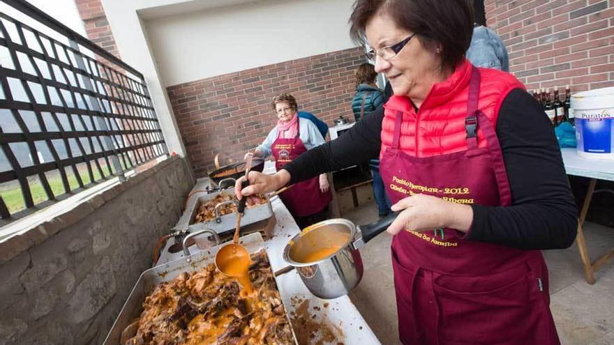 Mari Carmen Alonso echa salsa en una fuente con cordero antes de llevarla al comedor.