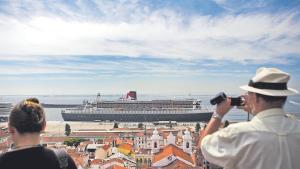 Dos turistas observan un buque atracado en el puerto de Lisboa.