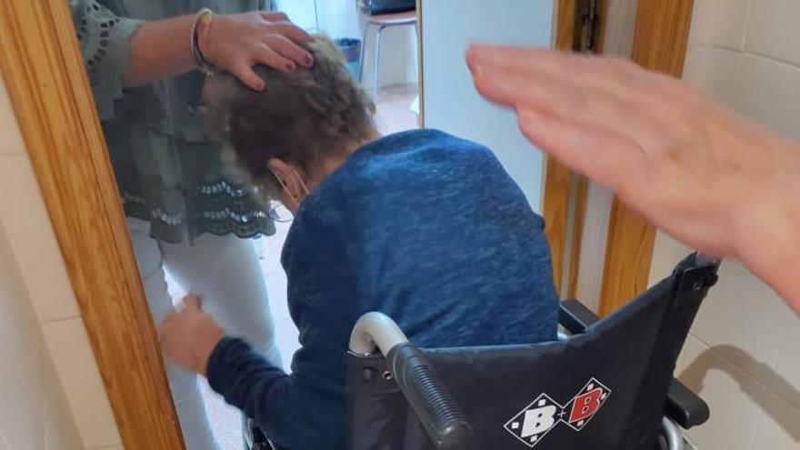 La doctora asiste a una mujer en el pasillo al no caber la silla de ruedas