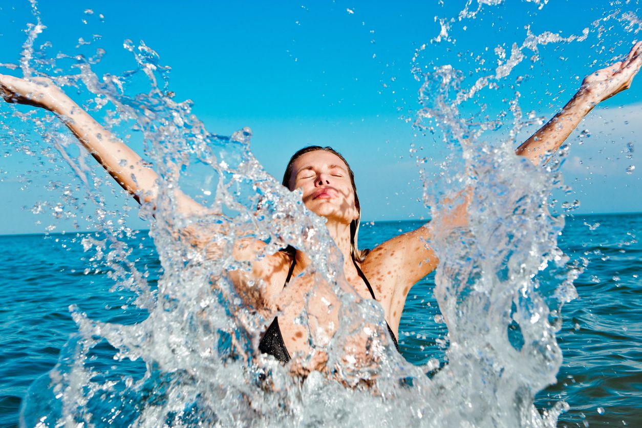 Mujer refrescándose en la playa