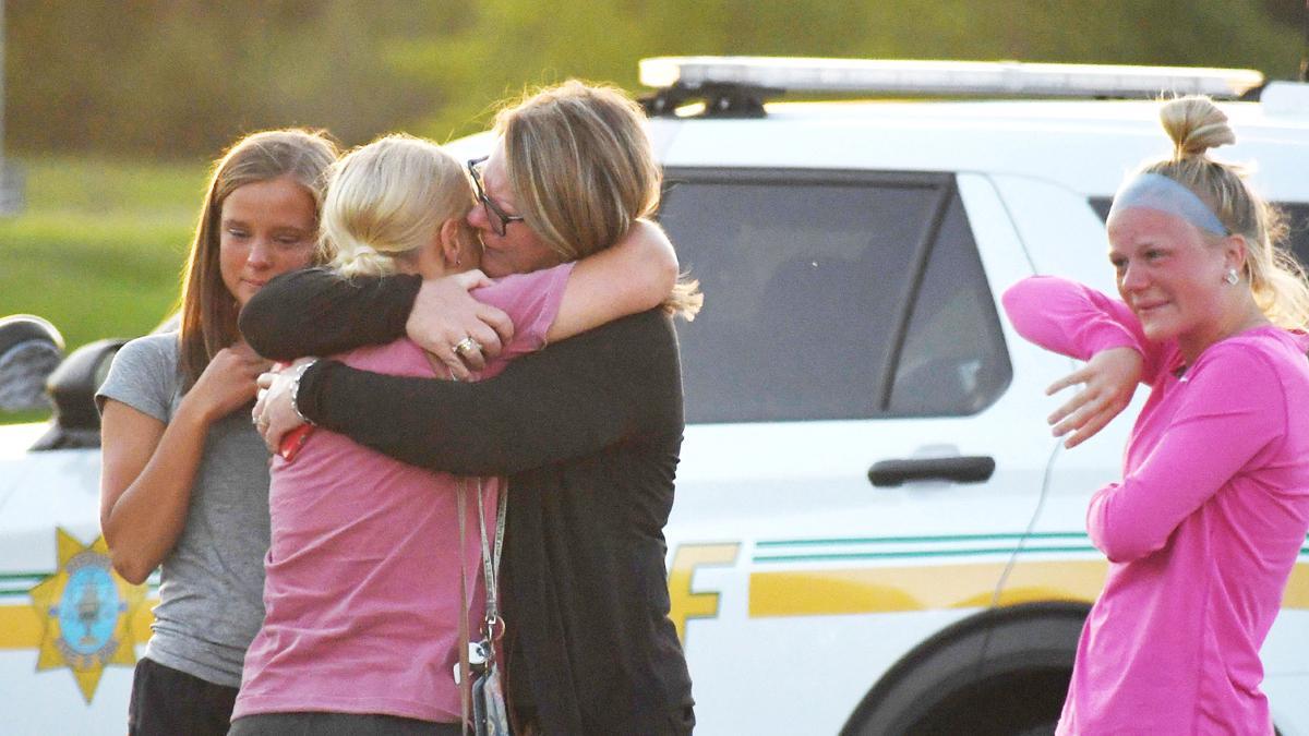 Un grupo de gente se consuela y se abraza después del tiroteo ocurrido en la iglesia Cornerstone, en Ames, Iowa