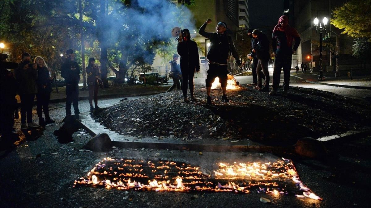 Manifestantes queman la bandera estadounidense frente al Palacio de Justicia en Portland, Oregón.