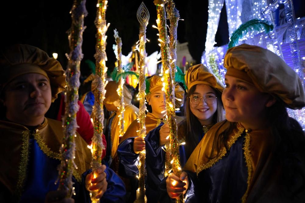 Los Reyes Magos, escoltados por pajes reales y bailarinas, reparten entre el público 800 kilos de caramelos y gominolas