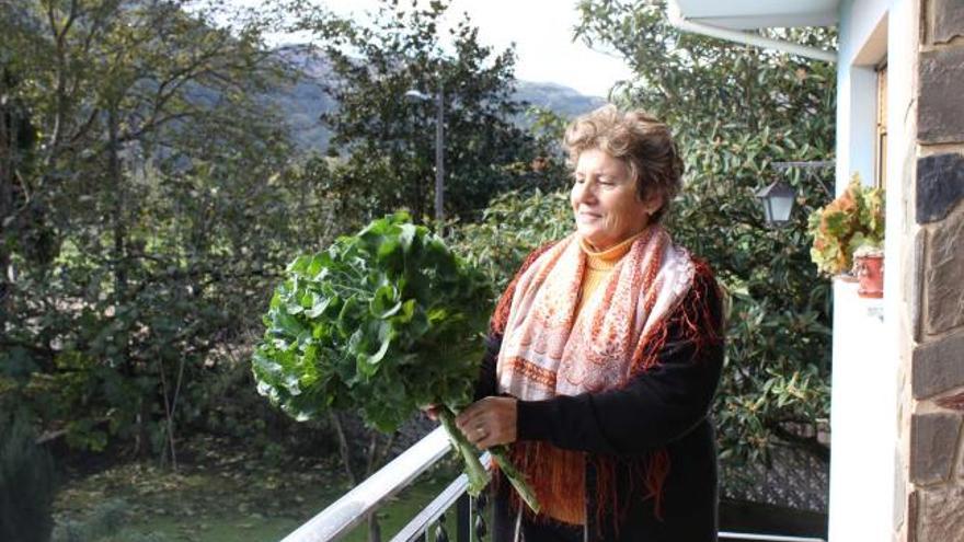 Anita Fernández, a la puerta de su casa, con unas berzas como las que le regaló a la Princesa Letizia en su visita a Bueño.