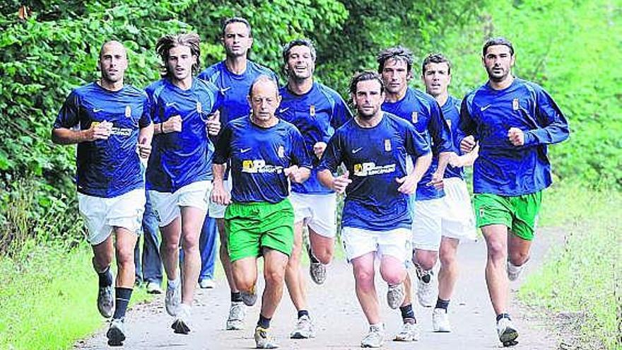Los jugadores del Oviedo, corriendo, junto al fisioterapeuta Manuel Barreto.
