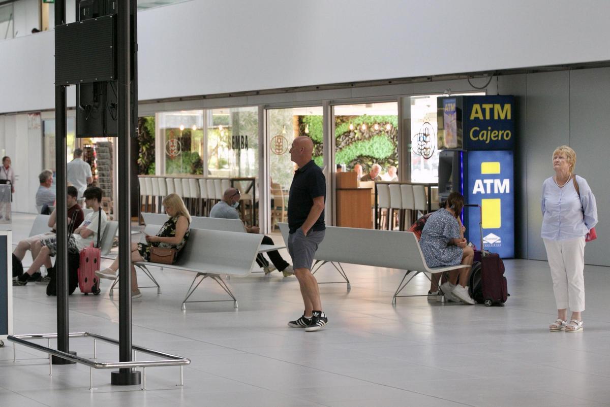 Pasajeros esperando en los pasillos del aeropuerto de Corvera para embarcar.
