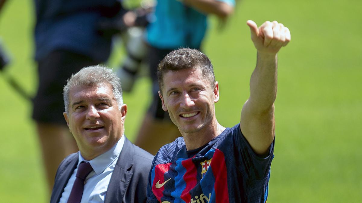 Robert Lewandowski sobre el césped del Camp Nou junto al presidente Joan Laporta.