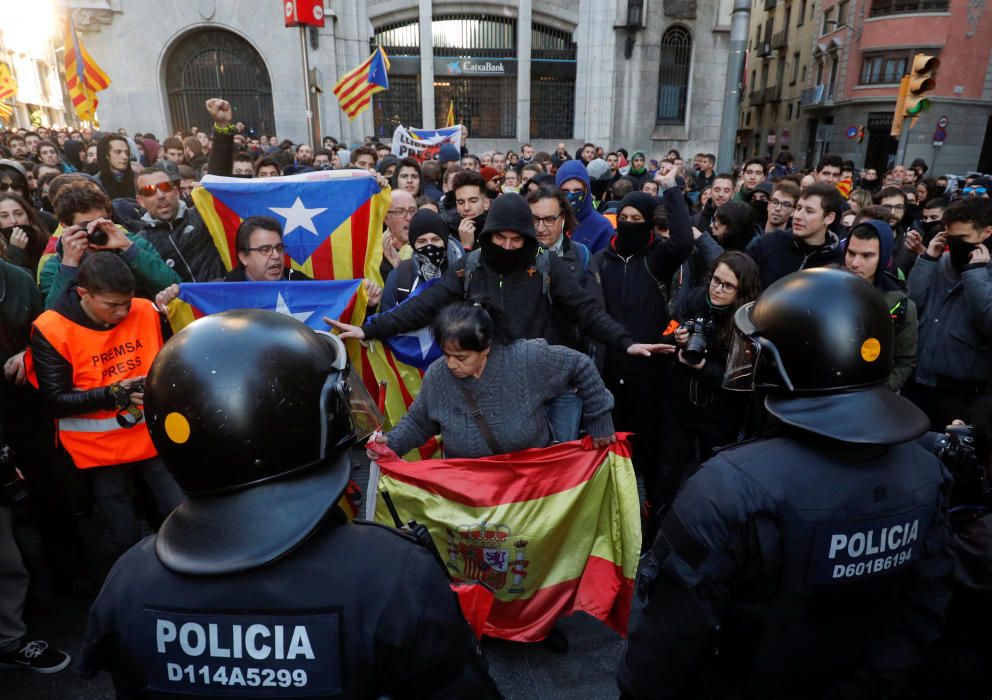 Riot police guard as a woman with Spanish flag ...
