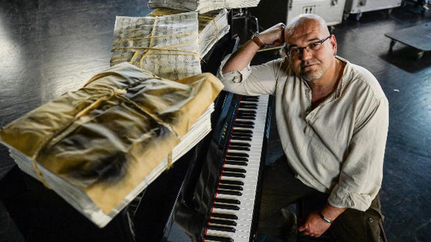 El escritor Alexis Ravelo, el pasado jueves en el Teatro Pérez Galdós, sentado ante el piano con parte de las partituras de atrezo que utilizarán en el espectáculo.