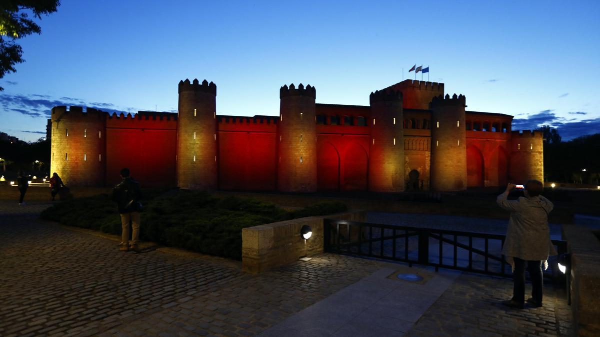 La Aljafería se iluminó por la noche con los colores de la cuatribarrada aragonesa.
