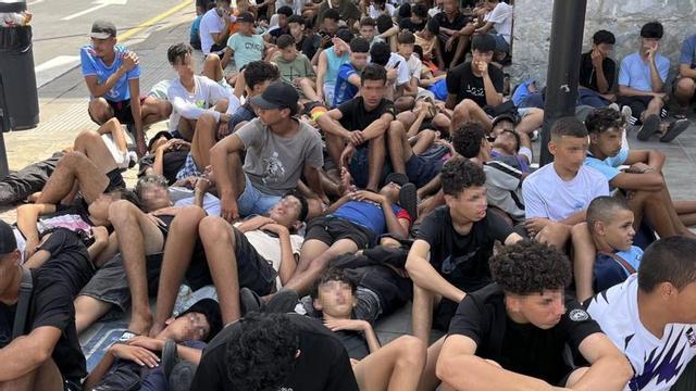 Menors migrants, davant la direcció de la Policia Nacional, a Ceuta. | REDUAN / EFE
