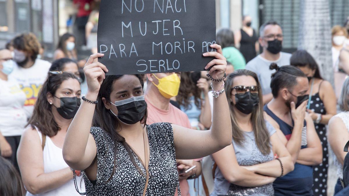 Un mujer con un cartel en el que se lee: `No nací mujer para morir por serlo´, participa en una concentración feminista en la Plaza de la Candelaria en repulsa por todos los feminicidios.