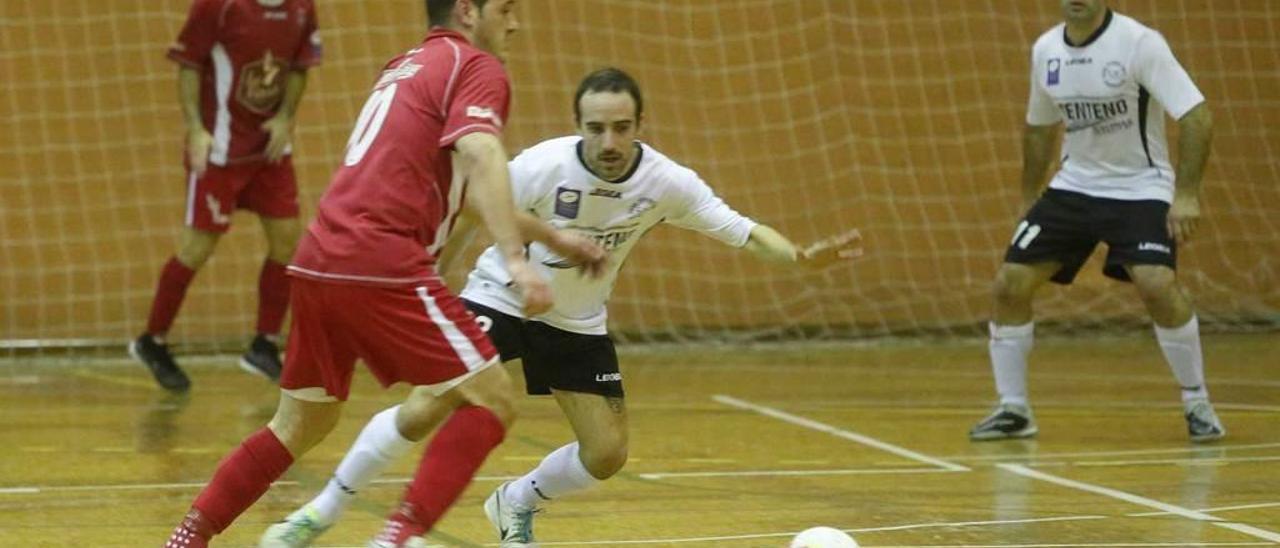 Un jugador del Gijón Playas trata de irse de la presión del Cinco As.