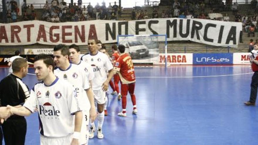 Los jugadores se saludan con el famoso cartel en el fondo.