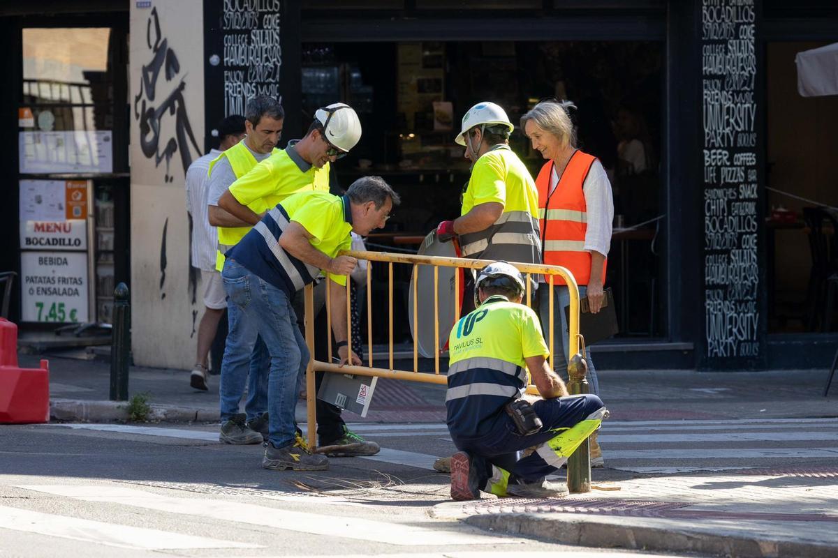 Varios operarios cortan una de las calles de la zona.