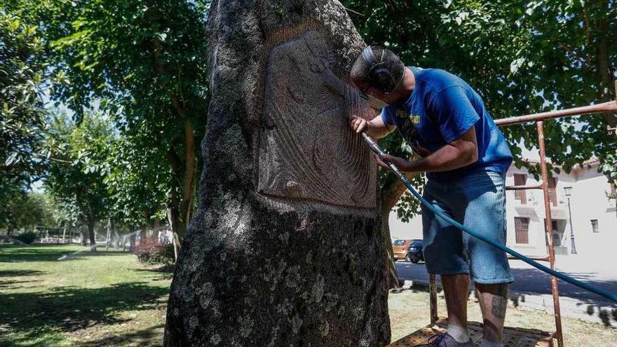 A la izquierda, el cantero Raúl Moreno de Paz en pleno trabajo en el relieve y a la derecha el joven con la pieza.