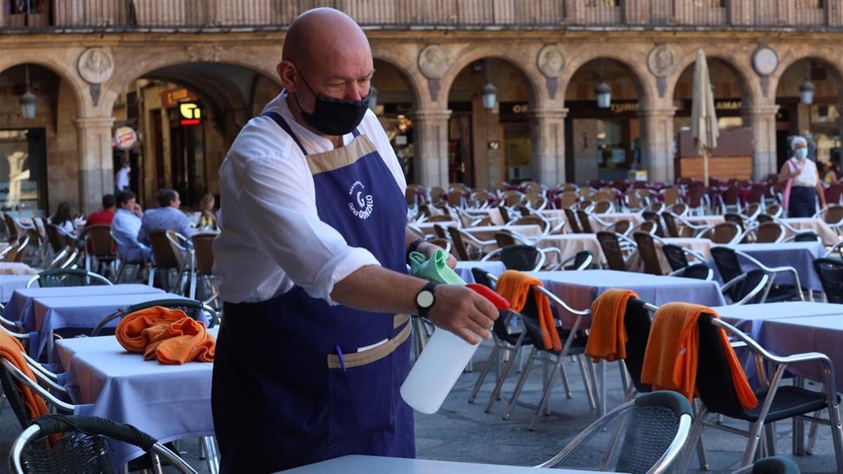 GRAF8987  SALAMANCA  02 09 2020 - Un camarero trabaja en la terraza de un restaurante de la plaza mayor de Salamanca  este miercoles  Paciencia y temor son las palabras mas usadas por los salmantinos a la hora de hace frente a las nuevas restricciones sociales y economicas dictadas por la Junta para contener los contagios de la covid-19 y que entran en vigor mananas  unas medidas que nadie quiere pero que consideran necesarias para salir adelante  EFE  J M Garcia