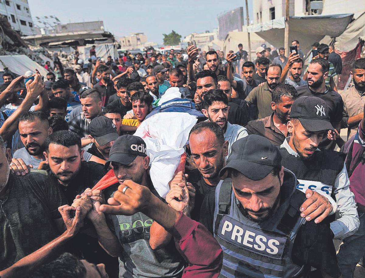 Los palestinos llevan el cuerpo del corresponsal de Al Jazeera, Anas al Sharif, que murió junto con otros periodistas en un ataque aéreo israelí, en su funeral ayer en la ciudad de Gaza.