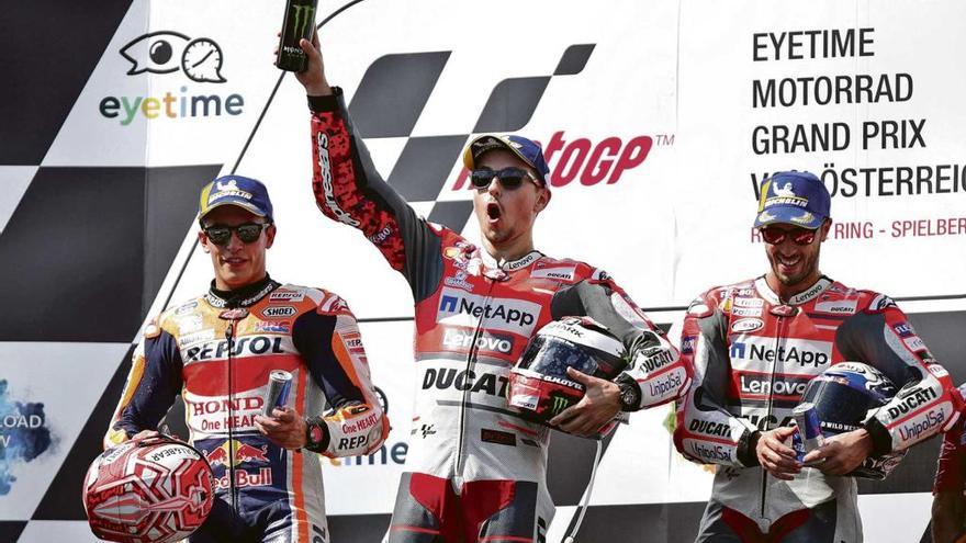 Lorenzo celebra con rabia su victoria en el podio de Spielberg ante la mirada de Márquez y Dovizioso.