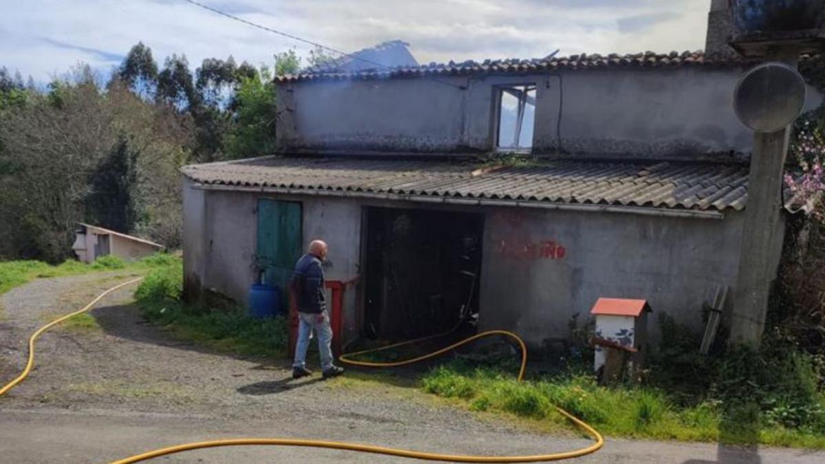 Uno de los residentes mira la casa, aún humeante, ayer.  | // L. O.